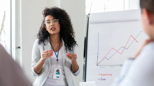 Health care worker standing in front of graph speaking