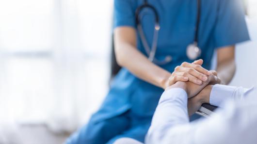 Doctor and patient holding hands.