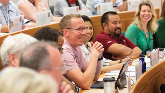 Executive participates in class discussion as fellow students actively listen.