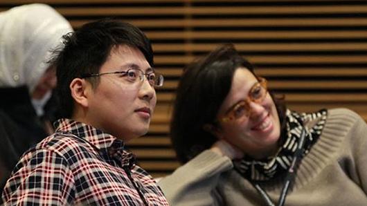 Scholars in lecture hall engaged in faculty presentation