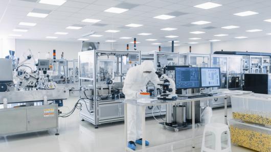 Lab worker in PPE working with laboratory equipment