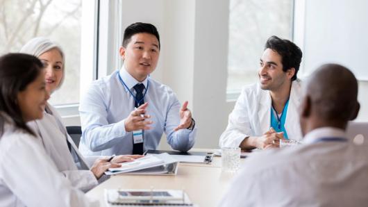 Health care leaders sitting at a conference table talking