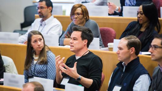 A diverse group of executives in a HBS classroom