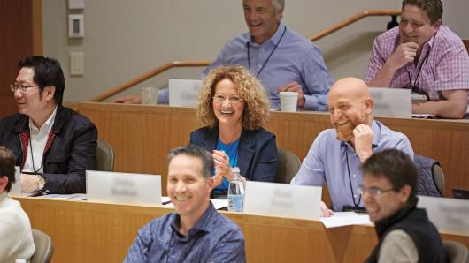 A diverse group of executives in a HBS classroom