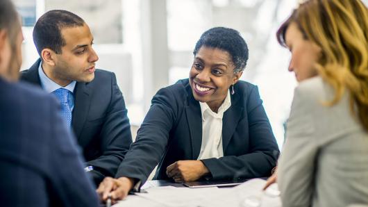 A black female and black male executive discussion a case with a white female and white male executives