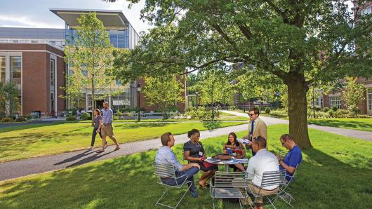 Executives in discussion at a lawn table on the HBS campus